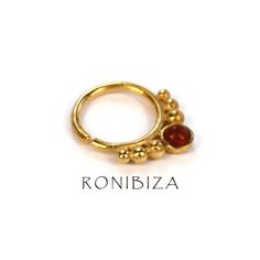 an image of a gold ring with red stones on the front and back side,