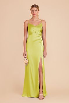 a woman wearing a lime green dress with a slit down the side and one leg