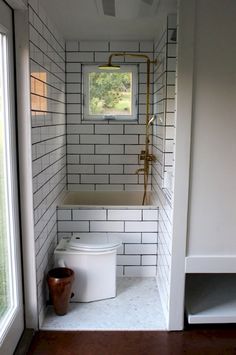 a white toilet sitting in a bathroom next to a window