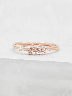 a pink diamond ring on top of a white surface