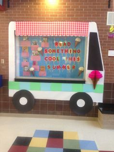 an ice cream truck is decorated with colorful squares and checkered flooring in front of a brick wall