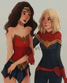 two women dressed as wonder and supergirls standing next to each other in front of a gray background