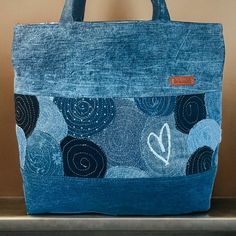 a blue tote bag sitting on top of a counter next to a wall with a clock