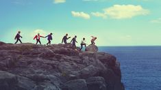 a group of people standing on top of a rocky cliff