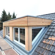 the roof of a house with windows and shingles on it's sides, is made of wood