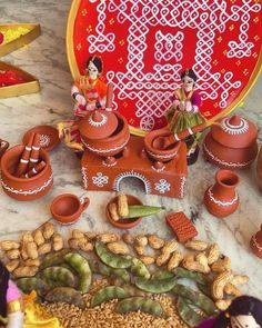 small figurines sitting on top of a table with food and decorations around them