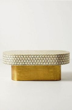 a white and gold bench sitting on top of a table