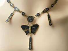 A stunning vintage Japanese Damascene necklace featuring a butterfly shaped pendant suspended from a chain of plaques featuring various inlaid scenes in silver and gold. Gilded brass settings with Niello and 24ct gold and silver inlay. Gilding is a little dull in line with a vintage item. Inlaid with K24 to the box clasp meaning the gold content. Necklace measures 20 inches around the neck Will arrive gift boxed. Free tracked shipping/UK next day delivery. Traditional Enamel Necklaces For Formal Occasions, Antique Enamel Necklace For Formal Occasions, Traditional Gold Jewelry With Black Enamel, Elegant Gold Necklace With Inlay, Gold Pendant Jewelry With Inlay, Ceremonial Gold Jewelry With Black Enamel, Vintage Gold Jewelry With Inlay, Vintage Necklaces With Inlay For Gifts, Antique Black Enamel Necklaces For Gift