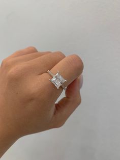 a woman's hand with a diamond ring on it