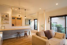 a living room filled with furniture next to a kitchen and an open door leading to a patio