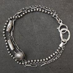 - Light and delicate layered chain bracelet - Made entirely of oxidised (darkened and polished) sterling silver (925) - 3 different chain styles - Hammered silver circle - Reticulated silver tubes and ball - All links soldered for extra strength - Lobster clasp fastening - Great for everyday wear and special occasions - Handmade to order - Tube dimensions: 0.16 x 0.40 inch (4 x 10 mm) - Ball diameter: 0.31 inch (8 mm) - Weight: approx. 7g Total length - 6 options:  6.5 inches (15.6 cm) 7 inches (17.8 cm) 7.5 inches (19 cm) 8 inches (20.3 cm) 8.5 inches (21.6 cm) 9 inches (22.9 cm)  or please let me know if you require a different length. Postage & Packaging: United Kingdom: Royal Mail 1st class Delivery time: usually 1-2 working days Worldwide: International Standard  Delivery time: 7-9 wo Silver Bracelets With Satellite Chain, Silver Bracelet With Satellite Chain, Silver Satellite Chain Metal Bracelet, Silver Metal Satellite Chain Bracelet, Silver Multi-strand Sterling Silver Bracelet, Cuff Bracelets Handmade, Layered Chain, Multi Strand Bracelet, Sterling Bracelets