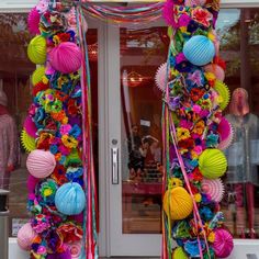 a decorated door with paper lanterns and streamers on the front entrance to a store