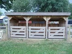 a wooden shed with three doors on the side