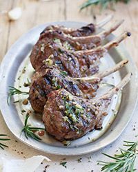 three lamb chops on a plate with herbs