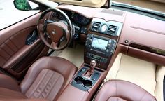 the interior of a car with brown leather seats and dashboards, including steering wheel