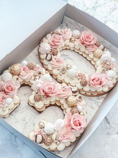 a cake in a box with flowers and seashells on the letters b, c