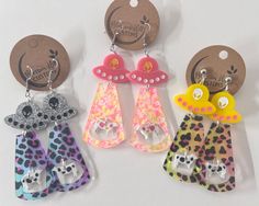 three pairs of animal print earrings are hanging from the back of each earring, and one pair is shaped like a giraffe