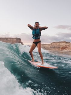 a woman riding a surfboard on top of a wave