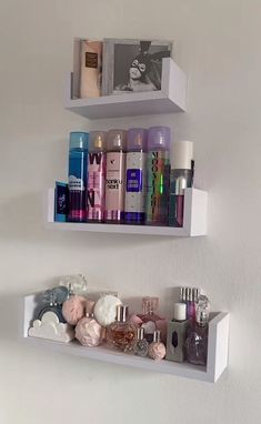 two white shelves filled with different types of perfumes and personal care products on them