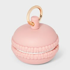 a pink container with a gold ring on the top that is shaped like a donut