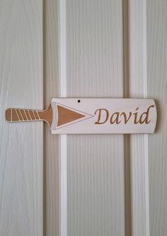 a wooden sign that says david on the side of a door with a toothbrush sticking out of it