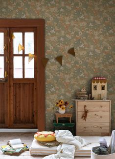 a room with an open door and some pillows on the floor next to a table