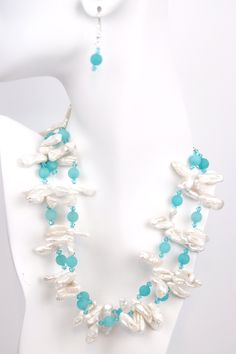 Dive into a sea of serenity with this Ocean Breeze necklace. The two strands of white Biwa pearls symbolize femininity and purity, while the matte turquoise rounds add a touch of color and vibrancy. Swarovski© crystal adds a touch of sparkle, making this necklace perfect for all occasions. The silver adjustable chain makes it easy to customize the length, so you can wear it any way you like. Soak up the sun and feel the sand between your toes while wearing this beautiful piece of jewelry. Elegant Double Strand Turquoise Beaded Necklace, Elegant Turquoise Double Strand Beaded Necklaces, Turquoise Pearl Jewelry With Pearl Charm, Elegant Turquoise Pearl Jewelry With Pearl Charm, Turquoise Pearl Drop Jewelry, Elegant Turquoise Beaded Necklaces With Pearl Chain, White Multi-strand Jewelry With Natural Stones, Turquoise Jewelry With Pearl Chain And Round Beads, White Double Strand Natural Stones Jewelry