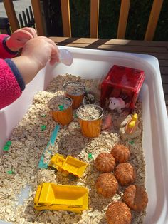 a child is playing with food in a play tray