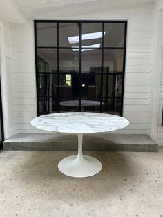 a white table sitting in front of a window