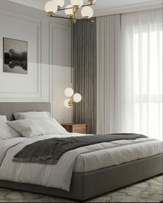 a bedroom with a large bed and two lamps hanging from the ceiling over it's headboard