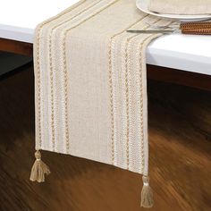 a table runner with tassels on it