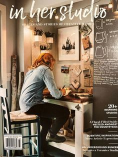 a woman sitting at a desk in front of a chalkboard with writing on it