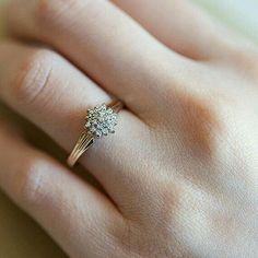 a woman's hand with a diamond ring on top of her finger and an engagement band