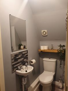 a bathroom with a toilet, sink and mirror