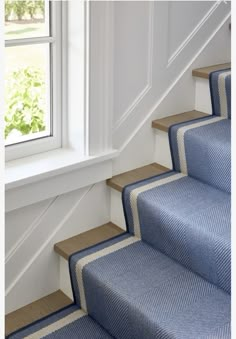 blue carpeted stairs leading up to a window