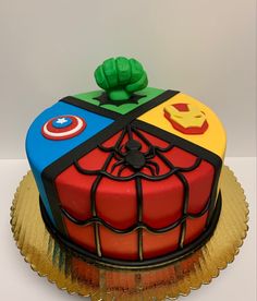 a birthday cake decorated to look like a rubik cube with captain america and iron man symbols on top