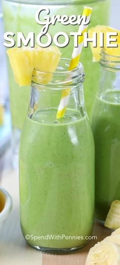 two mason jars filled with green smoothie next to sliced bananas