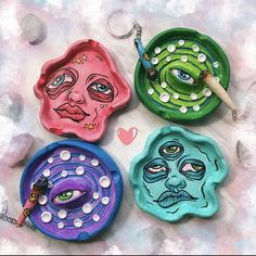 four ceramic plates with faces painted on them