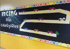 a bulletin board with cars on it in a school hallway, and the words racing into children's gardens