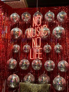 disco balls hanging from the ceiling in front of a sign that says no music, no life