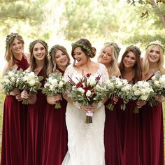 a group of women standing next to each other holding bouquets