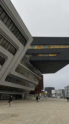 two people walking in front of a large building