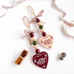 some ornaments are hanging on a white surface with ribbon and tags attached to them that say peace, merry