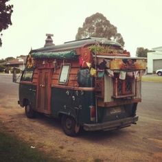 an old van is parked on the side of the road with plants growing out of it