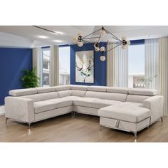 a large sectional couch in a living room with blue walls and wood flooring, along with a painting on the wall