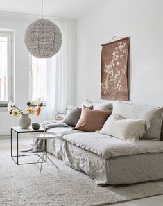 a living room filled with lots of furniture and decor on top of a white rug