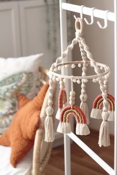 a bed with a white metal frame and some tassels hanging from it