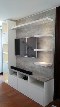 the entertainment center is built into the wall with white shelves and shelving units on each side