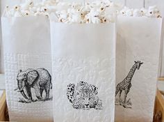 three paper bags with animals and giraffes on them sitting in a basket