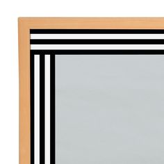 a black and white striped framed mirror on a wooden frame against a plain wallpapered background